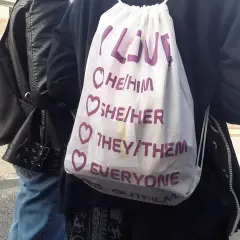 Torba z napisem "Miłość" i zaimkami: he/him, she/her, they/them, everyone. Wyraz wsparcia dla osoby niebinarnej.